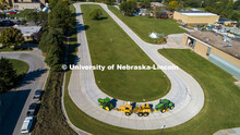 A tractor pulls the test car (yellow) and an additional tractor for weight as it rounds the test tra