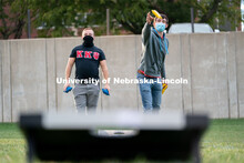 Students toss beanbags during the ASUN Cornhole Competition at the Cather-Pound Greenspace on Wednes