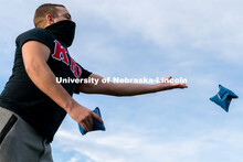 Kappa Kappa Psi’s Jacob Coughlin throws a beanbag during the ASUN Cornhole Competition at the Cath