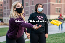 Kappa Kappa Gamma’s Chloe McCauley (left) tosses a beanbag during the ASUN Cornhole Competition at