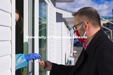 Chancellor Ronnie Green gives his saliva sample to Kaitlin Cartwright. Chancellor Green spoke with m