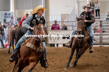 Members of the University of Nebraska rodeo team runs onto the track at the Nebraska Cornhusker Coll