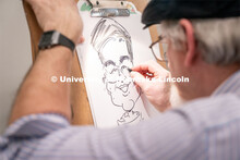 A caricature artist draws students during the End of Year Bash inside the East Campus Union on Satur