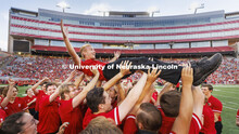 Drew Carlson, a freshman trumpet player from North Platte, is hoisted in the arms of the trumpet sec