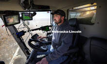 Surrounded by acres of popcorn outside his combine cab and multiple computer monitors inside the cab