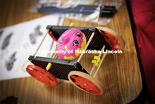 A doughnut squishy decorates a rubber-band powered car. Nebraska honors students Spencer Knight (blu