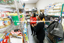 Trish Manga, in red, Maryam Sule, and Falesa Ivory, right, sort food for neighborhood groups in the 