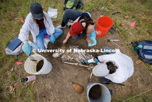 Sophia Huss, Tori Markwell and Zoe Durand work to excavate a plastic skeleton representing an appare