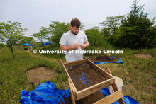 Dalton Carder, a senior in anthropology, looks at a piece sifted from his dig area. LuAnn Wandsnider