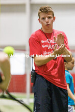Carson Linquist, a senior from Omaha, encourages a camper in the tennis relay. Husker Kids Camp. Jul