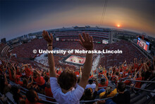 The crowd does the wave during a time out as the sun sets over Memorial Stadium. Volleyball Day in N
