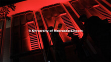 Army ROTC cadets carry their guidon past the red-lighted Schorr Center as they head into the stadium