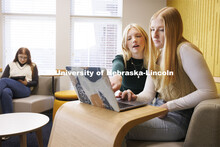 Madalyn Schoneman, center, and Alexis Tenorio look over work on the laptop as Sarah Danahy studies i