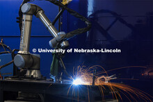 A robotic welder works its way around a metal sculpture welding in spots programmed into its compute