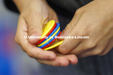 A second grader holds red, yellow and blue chips in his hand. The chips represent nutrients, sunshin