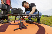 Biquan Zhao, Post-Doc Research Associate in Animal Science, attaches a multispectral camera to a dro