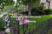 Recruits and Rho Gammas keep cool in the shade of Delta Delta Delta sorority while they await the ne