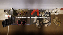 Chore shoes pile up by the front door of the apartment. Three student workers in the Animal Science 