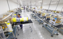 Supply cylinders containing food and bedding for the mice are attached to one of the isolators in th