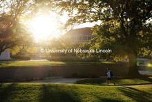 Morning sunlight shines on a student as they walk to class through the Sheldon Sculpture Gardens. Oc