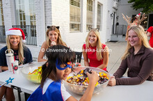 Maiya Thele, Noelle Brannen, Larin Frazier, and Zoe Leggett from the sorority Alpha Phi, hand out ca