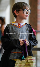 Small child dressed as a unicorn picks a piece of candy from a bowl. The University hosted a public 