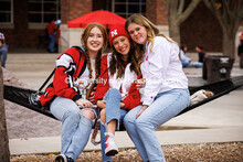 Friends sit together on the hammocks in front of the City Campus Union at the B1G Tailgate for the N