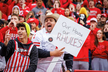 A fan cheers holding a sign saying “Our House our Rhules” at the Nebraska vs UCLA football game.