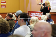 Sophomore Brady Cornelius takes photos inside U.S. senate candidate Dan Osborn’s election party in