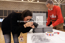 College of Journalism and Mass Communications student Sophia Walsh, left, takes a detail photo of vo