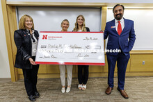 Charlie McCown and Kate Peterson, center, stand with their fourth-place check. Fall 2024 Center for 