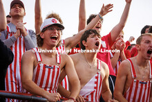 Fans wearing red and white striped overalls cheer at the Huskers vs. Wisconsin football game. Novemb