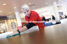 Cory Densberger, a Hospitality Service Associate in the Nebraska Union, wipes a table clean in the f