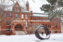 A student is framed by the Fragment XO sculpture as they walk past Architecture Hall. Snow day on Ci