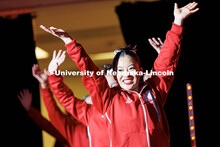 Members of the women’s gymnastics team peak through a curtain to watch their hype video before the