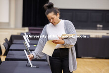 Ronesha Love, the Director of Career Services, puts information sheets on tables in preparation for 