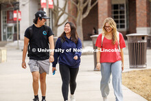 Zach Ahmann, Maddie Sue, and Payton Griese laugh together as they walk in front of the City Campus U