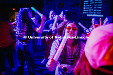 Lizeth Curiel, a Junior Accounting major, sings into her glowstick during the Huskerthon Rave. Huske