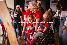 A child on Harley’s (right) pit crew throws a peace sign as she catches glimpse of the camera duri