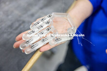 Teresa Monsees, a senior mechanical engineering major, holds the prototype of a robotic hand that wi