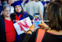 Jori Peters smiles as her photo is taken with a family member after the graduation ceremony. She ear