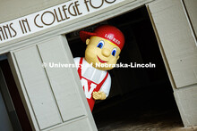 Ben Hastreiter as ‘Lil Red peaks out from behind a column in Memorial Stadium. Hastreiter has been