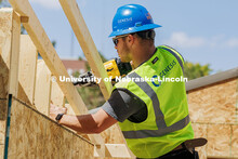 Eaden Holt, a junior Construction Management major, uses a nail gun while working on the frame of th