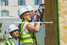 Ashley Garrard, a junior Construction Management major, hammers into the roof of a shed outside Kiew