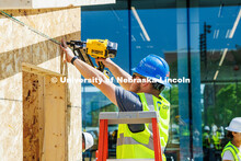 Eaden Holt, a junior Construction Management major, uses a nail gun while working on the frame of th