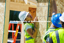 Senior, Jaeda Jeffries, holds a plank of wood as she works on her group’s shed for her Vertical Co