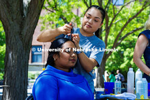 Bhavana Sreekumar, a Community and Regional Planning Graduate Student, gets her hair braided by an e