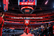 Faculty members march carrying the gonfallons into the 2025 Spring Graduate Commencement Ceremony in