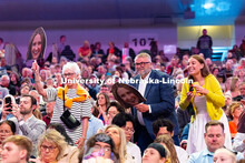 Family members cheer for a graduate during the morning commencement ceremony at Pinnacle Bank Arena.