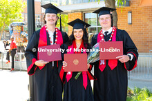 Triplets Josh, Paige and Drew Ferguson pose with their diplomas outside of Pinnacle Bank Arena after